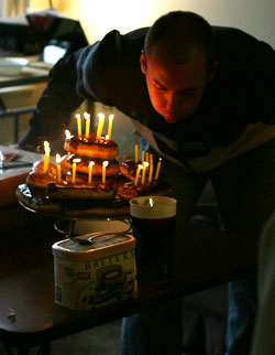 Travis blowing out candles on his birthday donuts